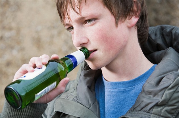 Nezletilý chlapec pije alkohol. Ilustraní foto