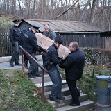Policist a pracovnci pohebn sluby vyn rakev s ostatky Ivana Jonka.