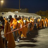 Afrit uprchlci stoj ve dne v noci v sicilskm pstavu, aby zkusili podat...