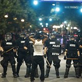 Vmluvn foto: bezmocn mu stoj ped hordou policist s obuky.