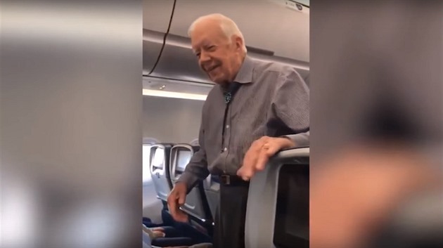 Jimmy Carter prochází letadlo a zdraví cestující.