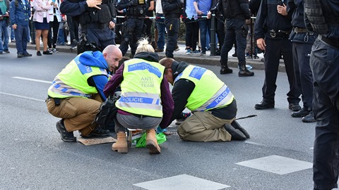 Přilepeným aktivistům museli pomoct členové anti-konfliktního týmu. Přilepeným aktivistům museli pomoct členové anti-konfliktního týmu.