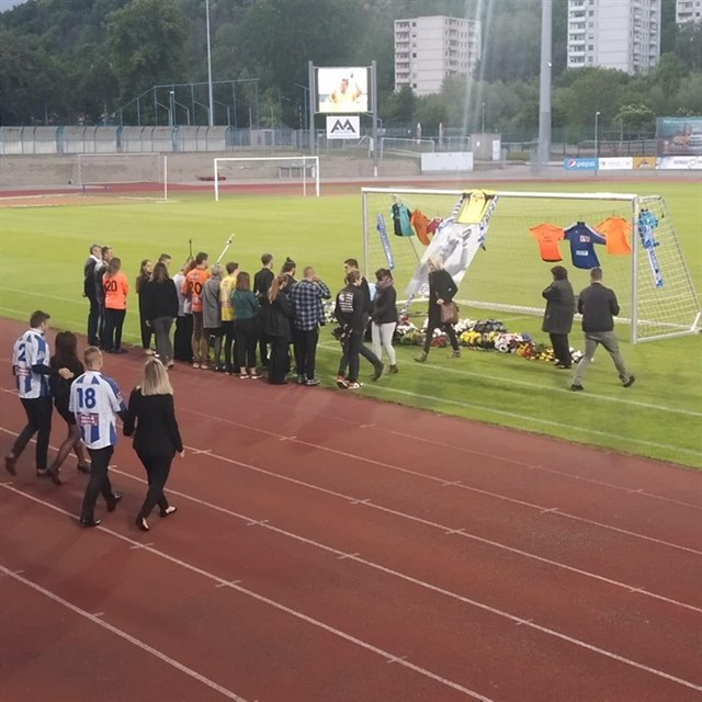 Lidé se Radimu Novákovi klaněli u brány s jeho portrétem a dresy.