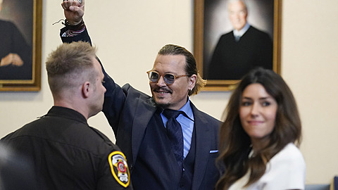 Johnny Depp ukazuje vítzné gesto.