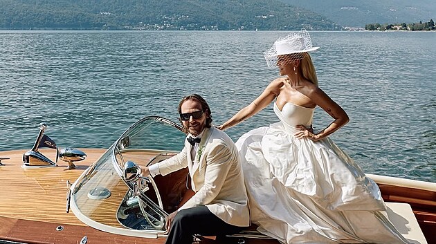Dokonalá italská romantika. Novomanželé pózovali na elegantním dřevěném motorovém člunu přímo na Lago Maggiore, za nimi se zvedají zelené svahy okolních hor.
