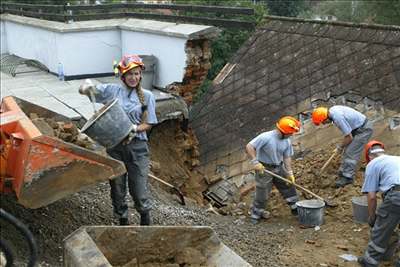 lenové civilní obrany odklízejí zeminu ze zasypaného domu