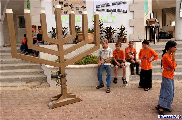 Dti stojí okolo Menorahu necadimské synagogy