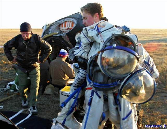 Návrat z vesmíru - Pozemní personál odnáí skafandry kosmonaut Sergeje...