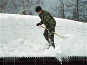 Vojáci pomáhají odstraovat sníh ze stech.