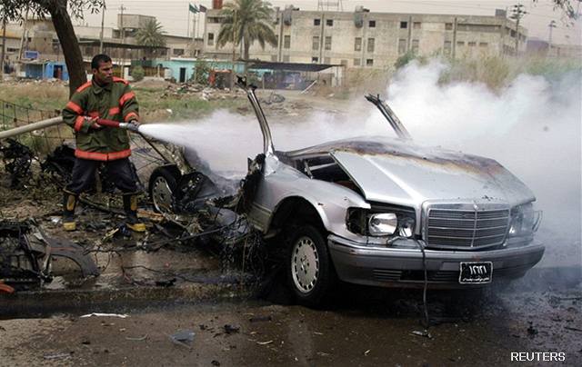 Irácký hasi likviduje poár jednoho z automobil