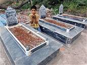 Pákistánský chlapec se modlí u hrobu svého starího bratra, kterého zabilo loské zemtesení. (8. íjna 2006)
