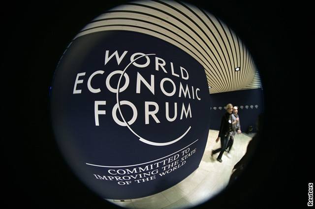 Dobrovolníci procházejí kolem loga Svtového ekonomického fóra konaného v Davosu.
