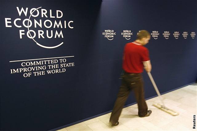 Dobrovolníci procházejí kolem loga Svtového ekonomického fóra konaného v Davosu.
