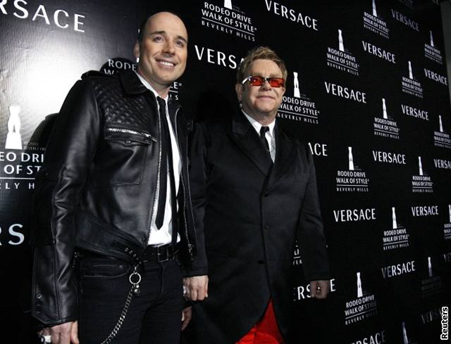 Elton John a jeho partner David Furnish pózují na galaveeru znaky Versace v...