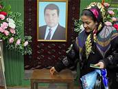 Turkmenská volika odevzdává svj hlas v místnosti, které dominuje portrét zesnulého Turkmenbaiho