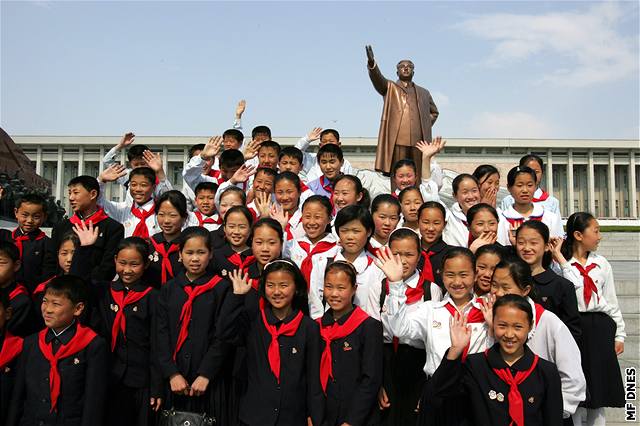 Pionýi v Pchjongjangu se pili poklonit Velkému vdci Kim Ir-Senovi. Jeho obí socha v pozadí.