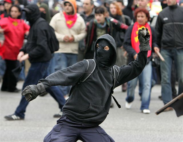 Demonstrant hází v Rustocku po policistech kameny