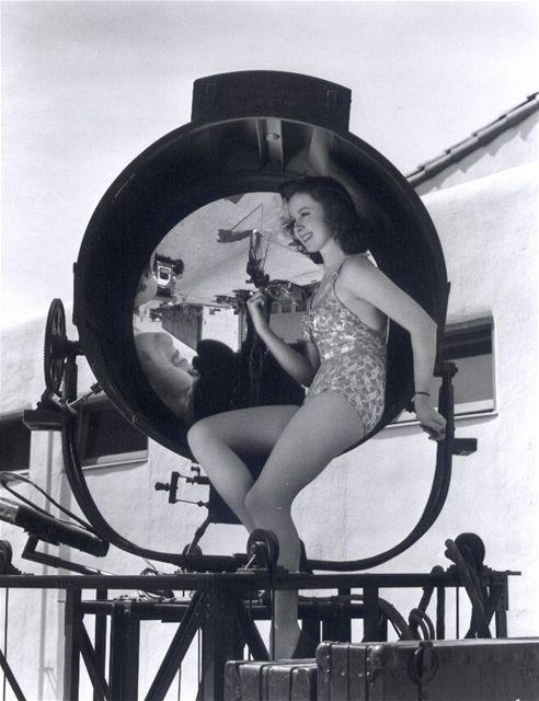 Pinup girl Susan Hayward poses with a 1930s Hollywood searchlight