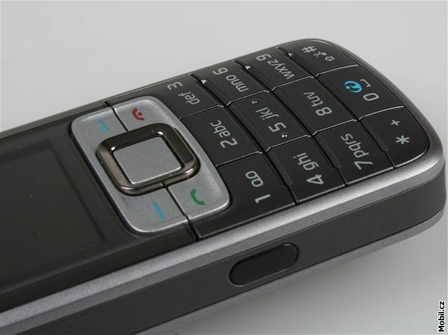 Pochromované tysmrné tlaítko obklopené dvma kontextovými klávesami a erveným a zelených telefonem