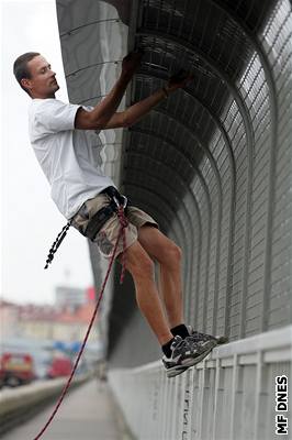 Horolezec Luká Exner se pokouí pelézt zábrany na praském Nuselském most.