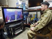 Ruský voják v eenském Grozném sleduje v televizi prezidenta Putina