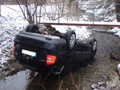 Více ne tunové auto musel vytáhnout z potoka na silnici speciální jeáb.