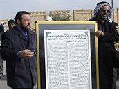 Saddámovi stoupenci nesou k hrobce desku s básní o diktátorovi.