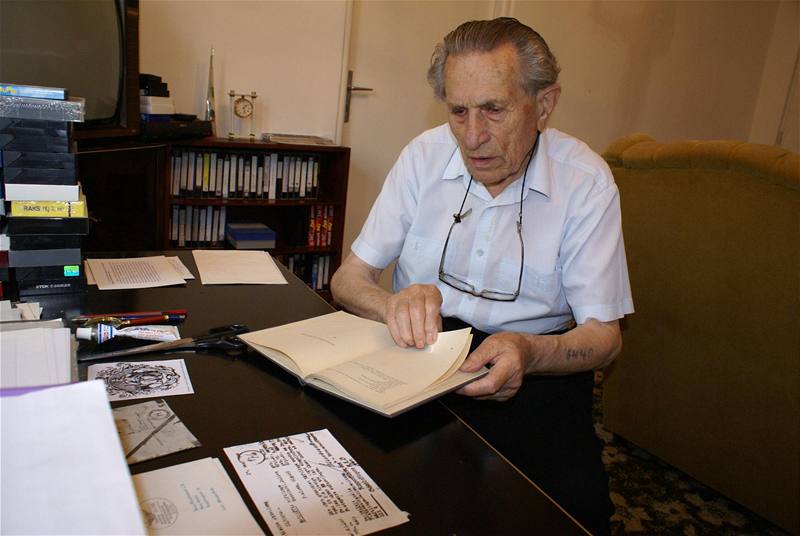 Adolf Burger ve své pracovn listuje prvním vydáním své knihy o záitcích z koncentraního tábora 
