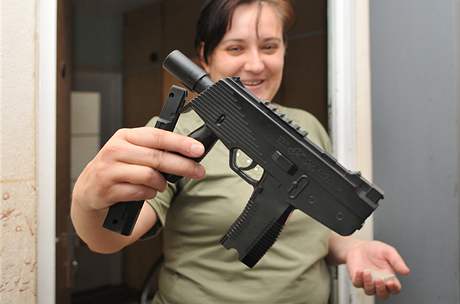 Matka dvou stelky ukazuje pistol na kulikov nboje, z n se stlelo.