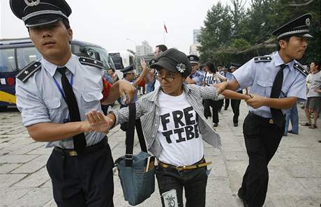 Písluníci bezpenosti odvádjí protestující od brány parku v Pekingu (13. srpna 2008)