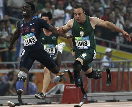Jihoafrický sprinter Oscar Pistorius (vpravo) dobíhá do cíle v závod na 100m na paralympiád v Pekingu.