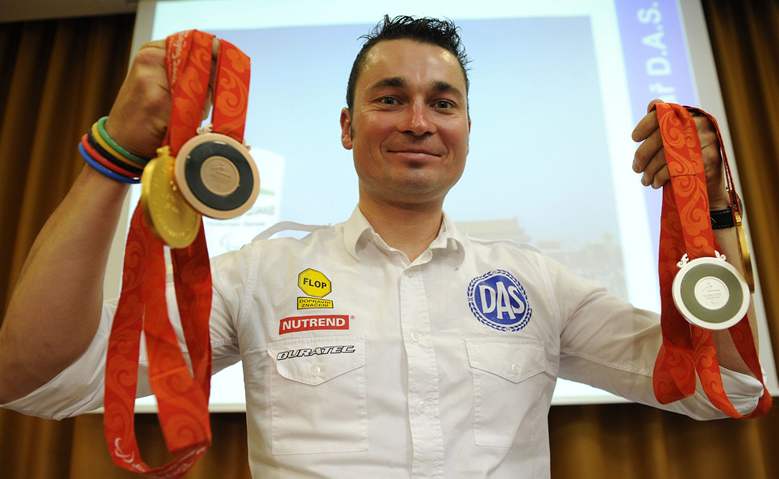 Cyklista Jií Jeek pózuje se tymi medailemi z paralympiády