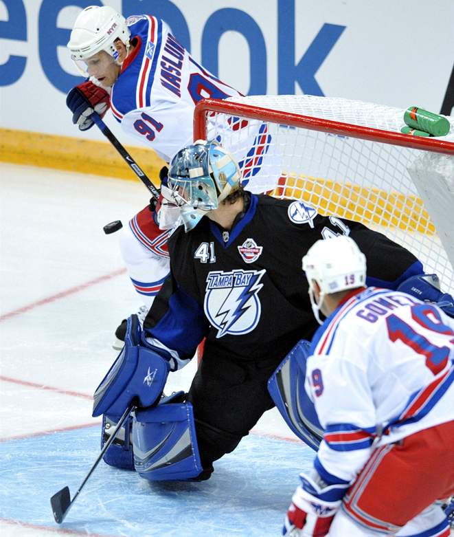 Markus Näslund (vzadu) a Scott Gomez z New York Rangers ped brankáem týmu Tampa Bay Lightning Mikem Smithem.