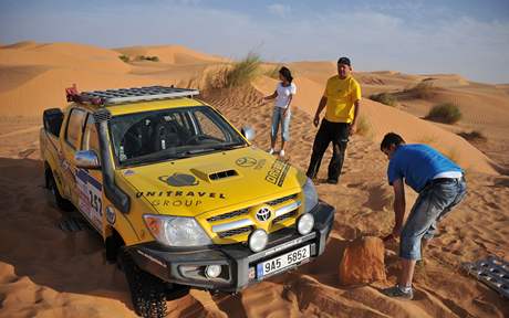 Autor reportáe Robert Sára (v modrém triku) se pokouí vyhrabat terénní toyotu z duny. Jeho snaha byla marná, vz musel z písku vytáhnout kamion.