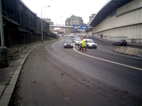 Dlníci odnáí kusy betonu, které padaly dol na silnici ped vjezdem do Strahovského tunelu.
