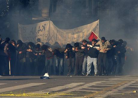 Studenti v aténských ulicích se chrání ped policejním slzným plynem.