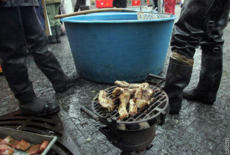 Prodejci kapr si peou maso na grilu.