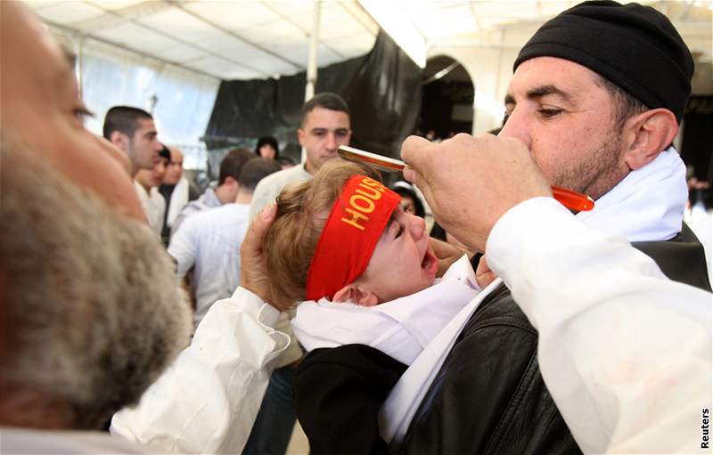 Mu v Libanonu poklepává bhem oslav svátku aúra, který slaví íité, hlavu dítte bitvou. (7. ledna 2008)