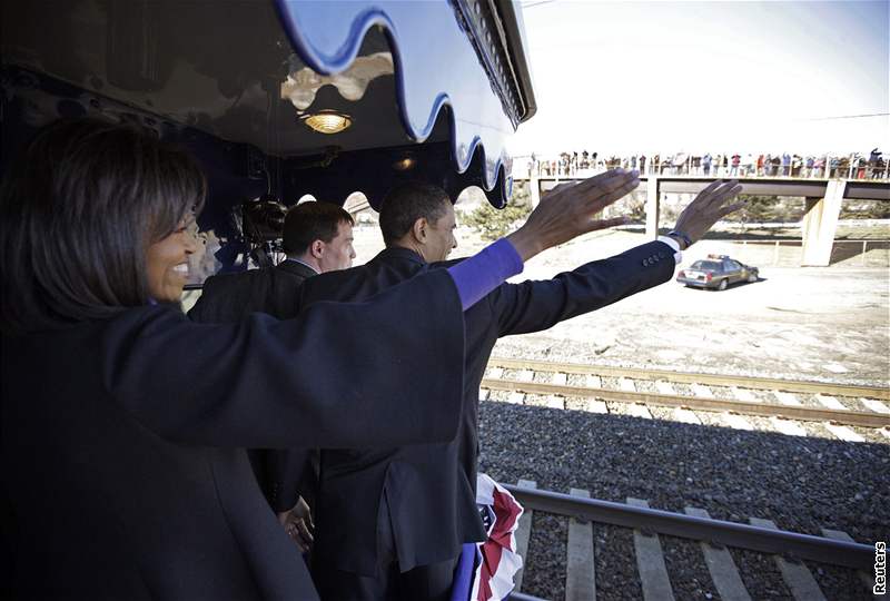 Barack Obama a jeho manelka Michelle mávají tisícm lidí kolem trati.