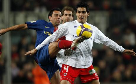 Barcelonský Xavi Hernandez (vlevo) v boji o mí s Dimasem Delgadem z Numancie. 
