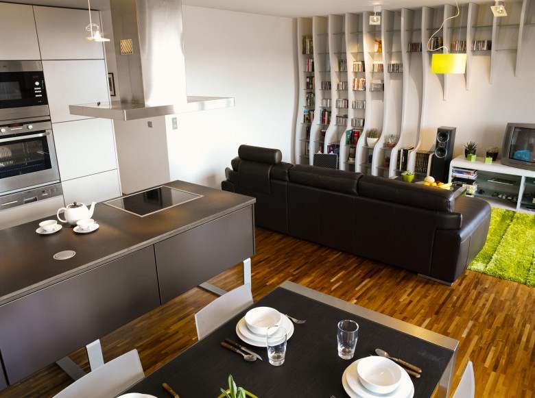 Obývací místnost s integrovanou kuchyní je sjednocena hndo-edou barevností