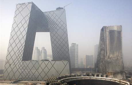 Pekingský hotel Mandarin Oriental (vpravo) zcela zniily plameny.