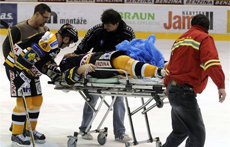 Litvínovský hokejista Jií légr opoutí na nosítkách ledovou plochu, mluví k nmu kapitán domácích Robert Reichel.