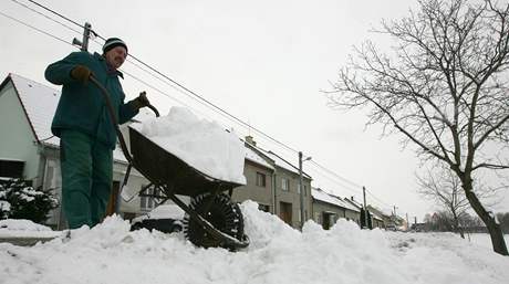 Obyvatel Lhoty pod Kosíem vyváí sníh ze dvora svého domu