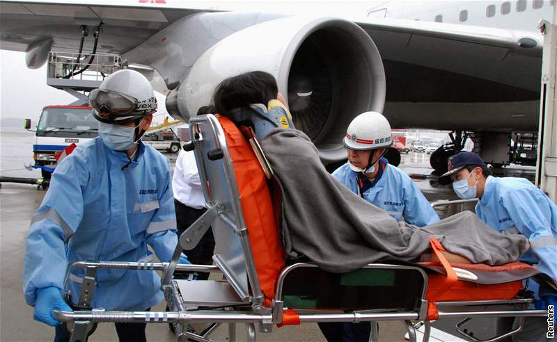 Záchranái penáejí na tokijském letiti pasaéra letadla Northwest Airlines, který se zranil pi turbulencích. (20. únor 2009)