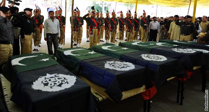 Pákistánská policie a píbuzní stojí u rakví s ostatky kadet zavradných pi atentátu na policejní akademii v Láhauru (31. bezen 2009)