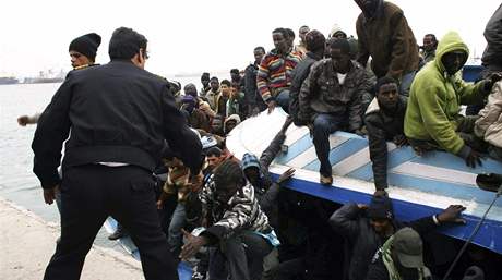 Libyjská policie pomáhá africkým bencm z petíené lodi. Plavidlo se dostalo do potíí v nedli v silné boui. (29. bezna 2009)