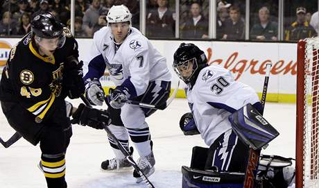 Boston - Tampa Bay: Domácí útoník David Krejí v anci ped gólmanem Mikem McKennou z Tampy Bay.