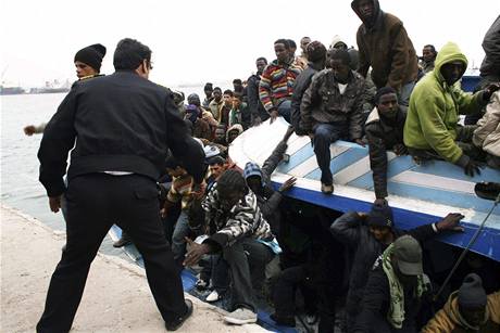 Libyjská policie pomáhá africkým bencm z petíené lodi. Plavidlo se dostalo do potíí v nedli v silné boui. (29. bezna 2009)