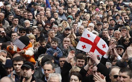 Nad hlavami demonstrant v Gruzii je gruzínská vlajka s erveným svatojiským kíem